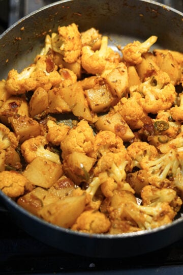 Cauliflower and potatoes mixed with spice mixture.