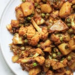 Aloo gobi matar in a white plate.