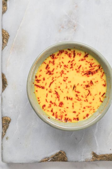 Saffron bloomed in milk in a small bowl.