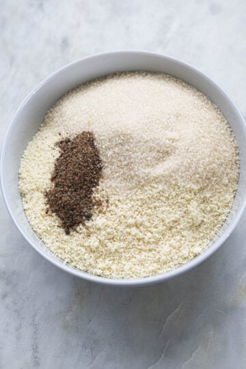 Almond flour, cardamom powder, and sugar in a bowl.