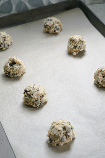 Scoops of cookie dough on a baking sheet.