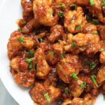 Gobi manchurian in a white bowl with green scallions.