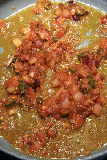 Crushed tomatoes added to pan.