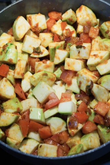 Zucchini and tomatoes added to pan.