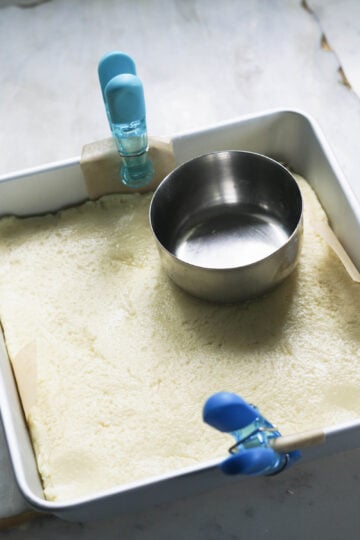 Burfi mixture spread into square pan.