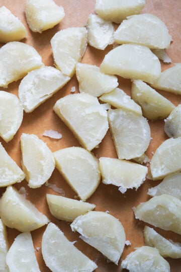 Cut potatoes on a cutting board.