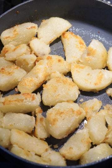Browned potatoes in a pan.