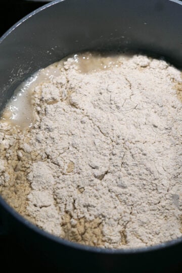 Water, oil, jowar flour, and salt in a pot.