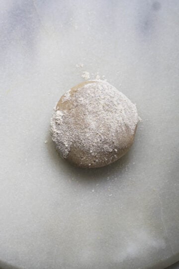 Sorghum flour dough ball with sorghum flour sprinkled on top.