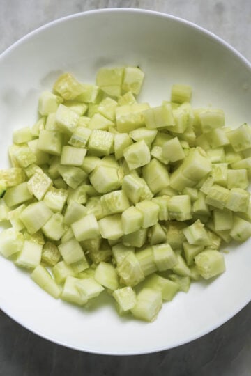 Chopped cucumbers in a mixing bowl.