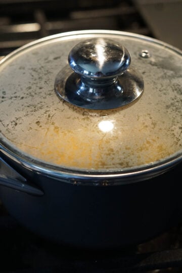 Covered pot on the stove with besan roti flour inside.