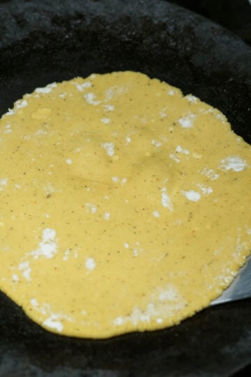 Besan ki roti cooking on a tawa.