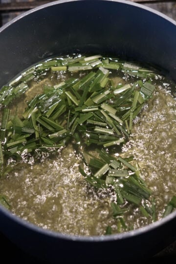 Lemongrass tea on a rolling boil in a pot.