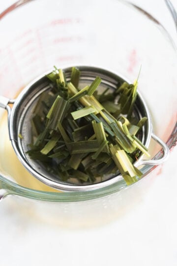 Strained lemongrass leaves in a strainer.