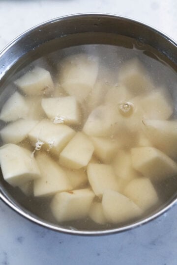 Cubed potatoes in a bowl of water.