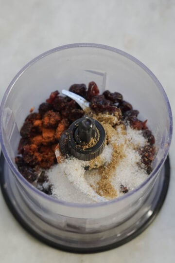 Dried cranberries and spices in a food processor.