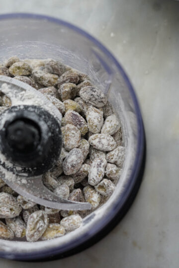 Flour coated pistachios in a food processor.