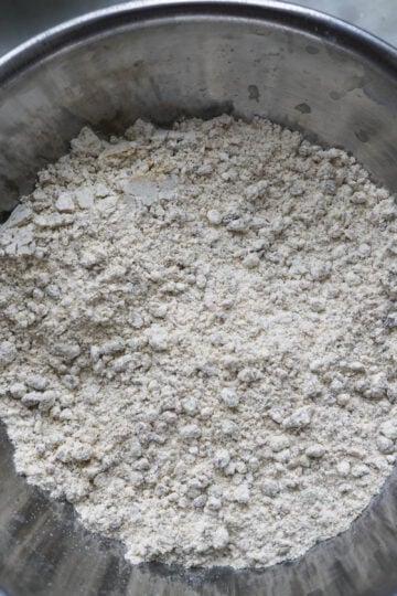 Flour, ground pistachios, salt, and baking powder mixed in a bowl.