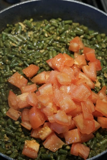Tomatoes and sugar added to pan.