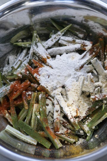 Okra, flours, and spices in a mixing bowl.