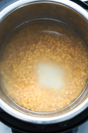 Toor dal and fenugreek seeds in an Instant Pot with water.
