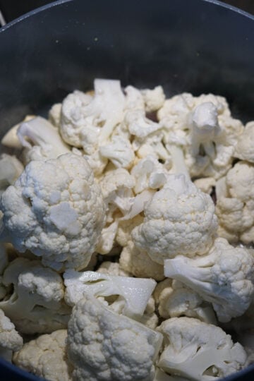 Cauliflower florets added to pan.