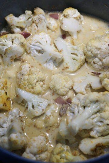 Coconut milk added to cauliflower florets.