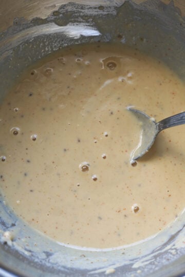 Besan gram flour batter in bowl.