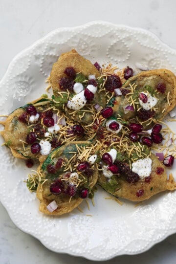 Assembled spinach leaf chaat on an ornate plate.