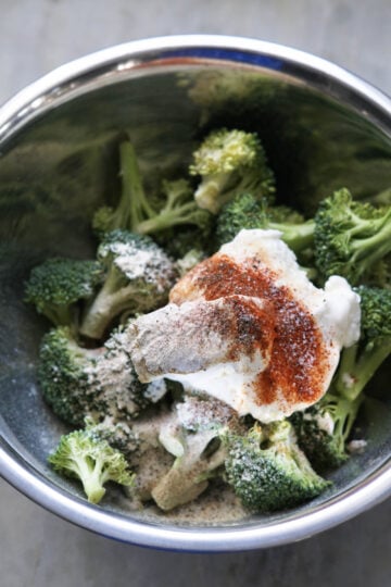 Broccoli in a bowl with cream cheese, yogurt, and spices.