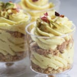 Eggless thandai mousse in serving cups garnished with rose petals and pistachios.